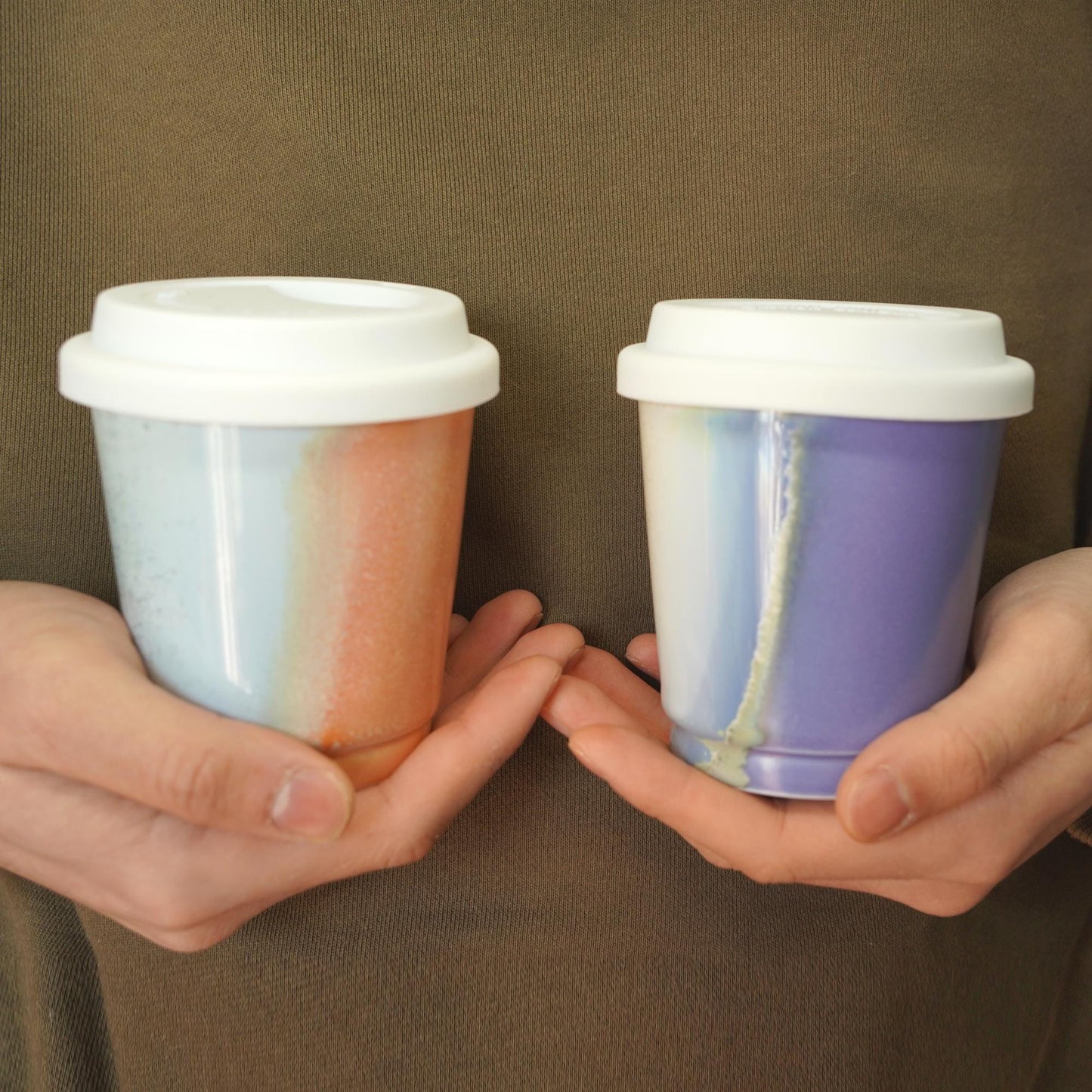 handhold purple orange comparison  reusable to-go mug with white lid - Extra size for smoothies. Ergonomic grip, eco-friendly stoneware.